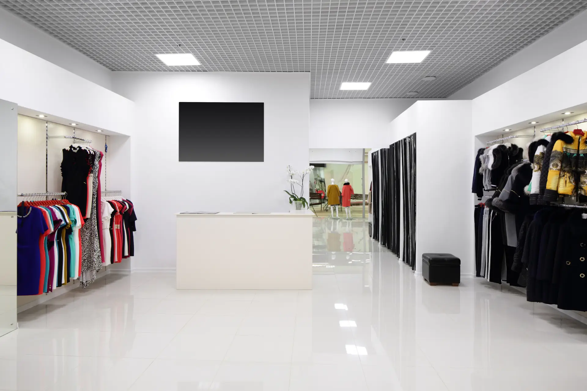Minimalist clothing store interior with white walls and racks.